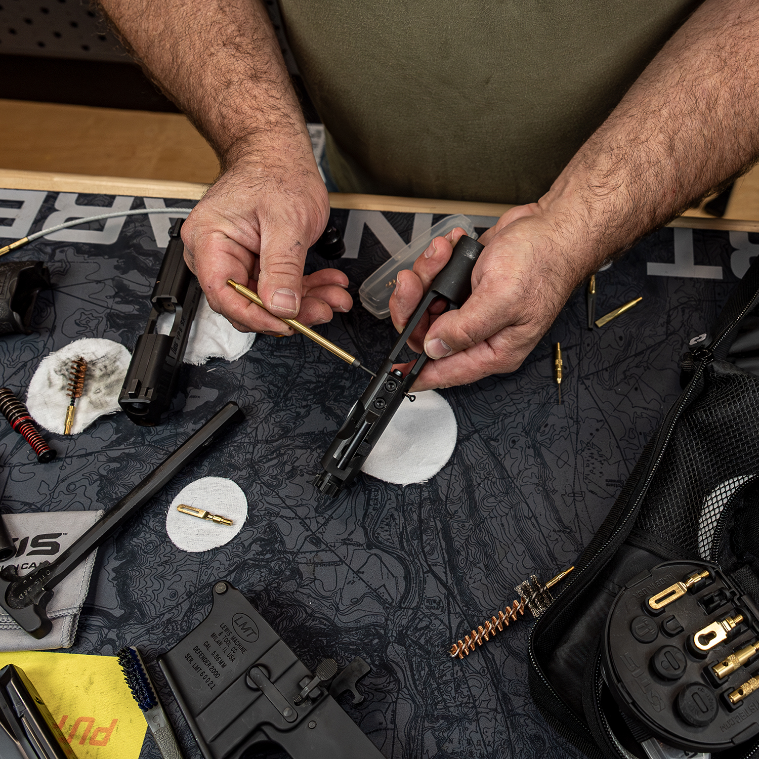 Man cleaning 9mm handgun using Otis Elite Universal Gun Cleaning Kit Components